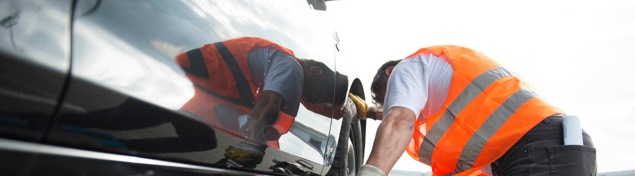 Herangehensweise Ausschnitt eines Bildes von einem Mitarbeiter, der ein Auto sichert.