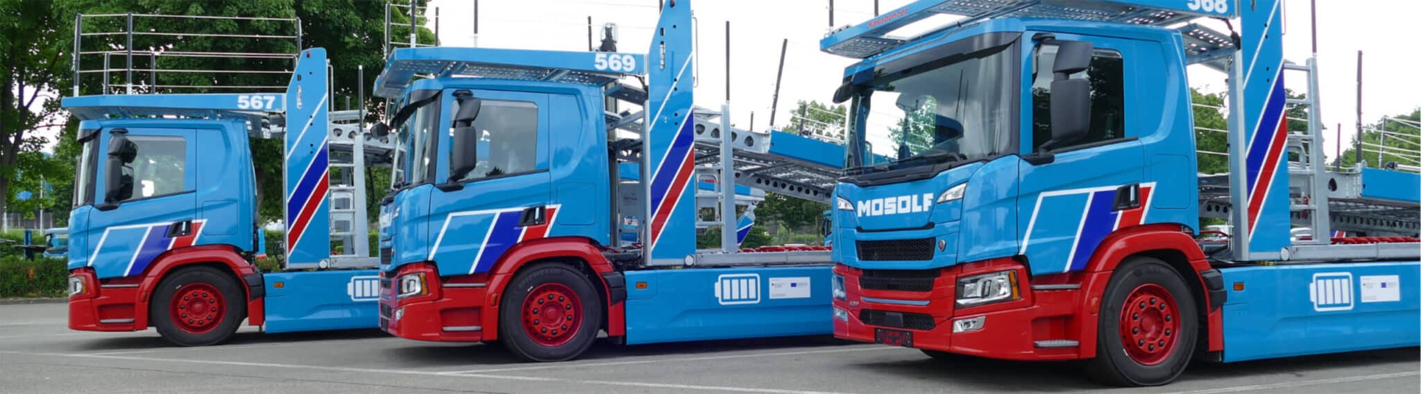 Drei E-LKWs stehen nebeneinander.